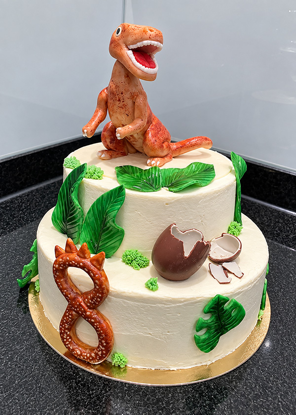 Motivtorten: Zweistöckige Dinosaurier-Torte mit Dino-Figur von Konditorei Niedermair